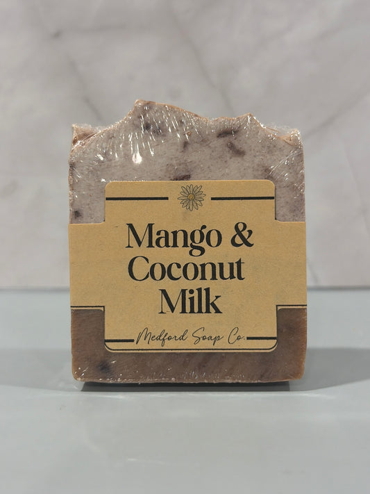 Bar of soap with a label reading 'Mango & Coconut Milk' on a light background