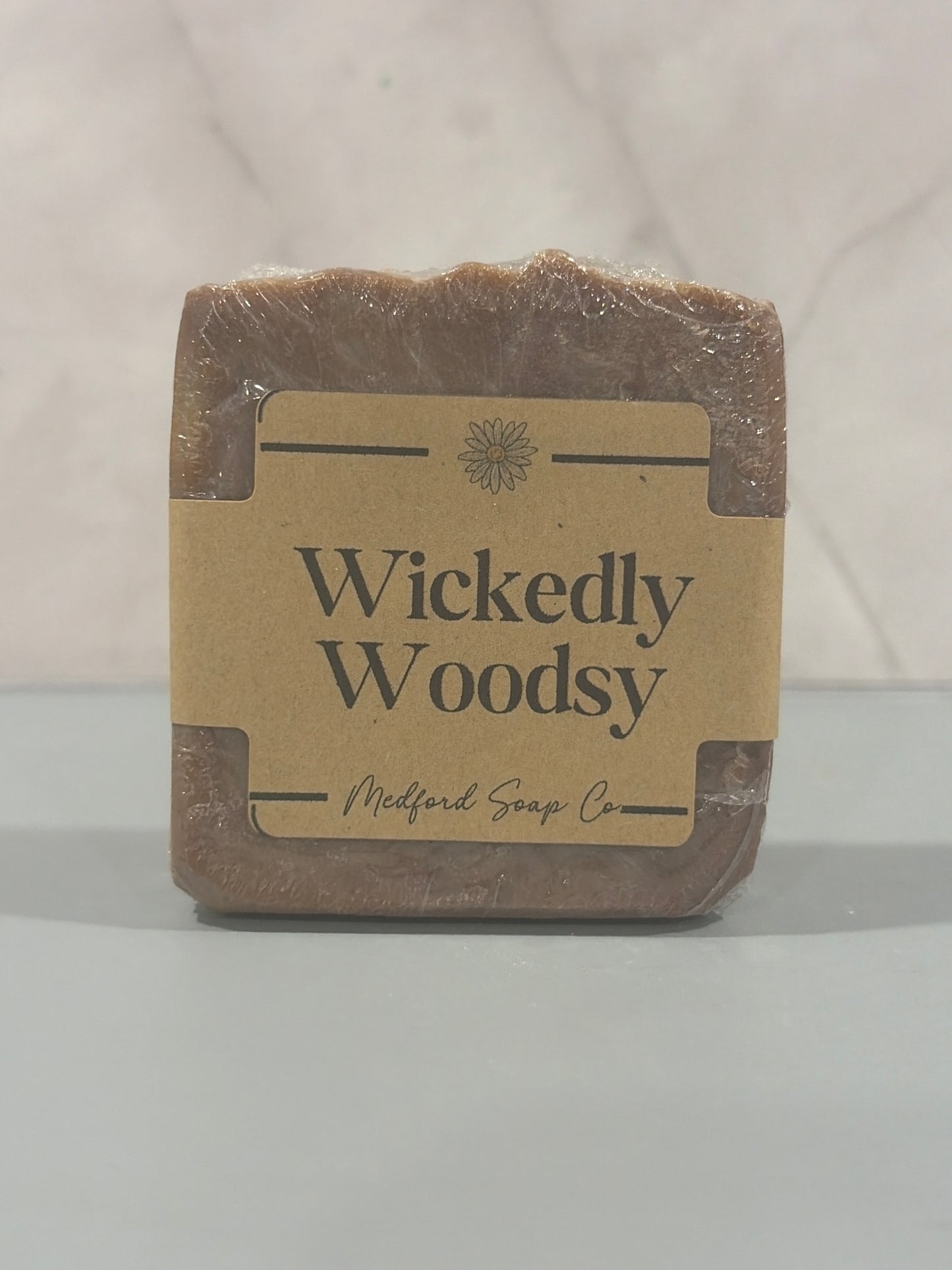 Bar of soap with 'Wickedly Woodsy' label on a white background