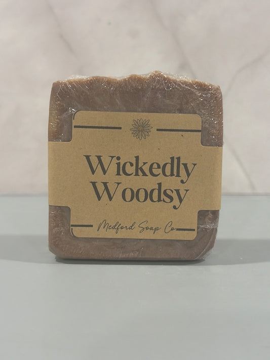 Bar of soap with 'Wickedly Woodsy' label on a white background