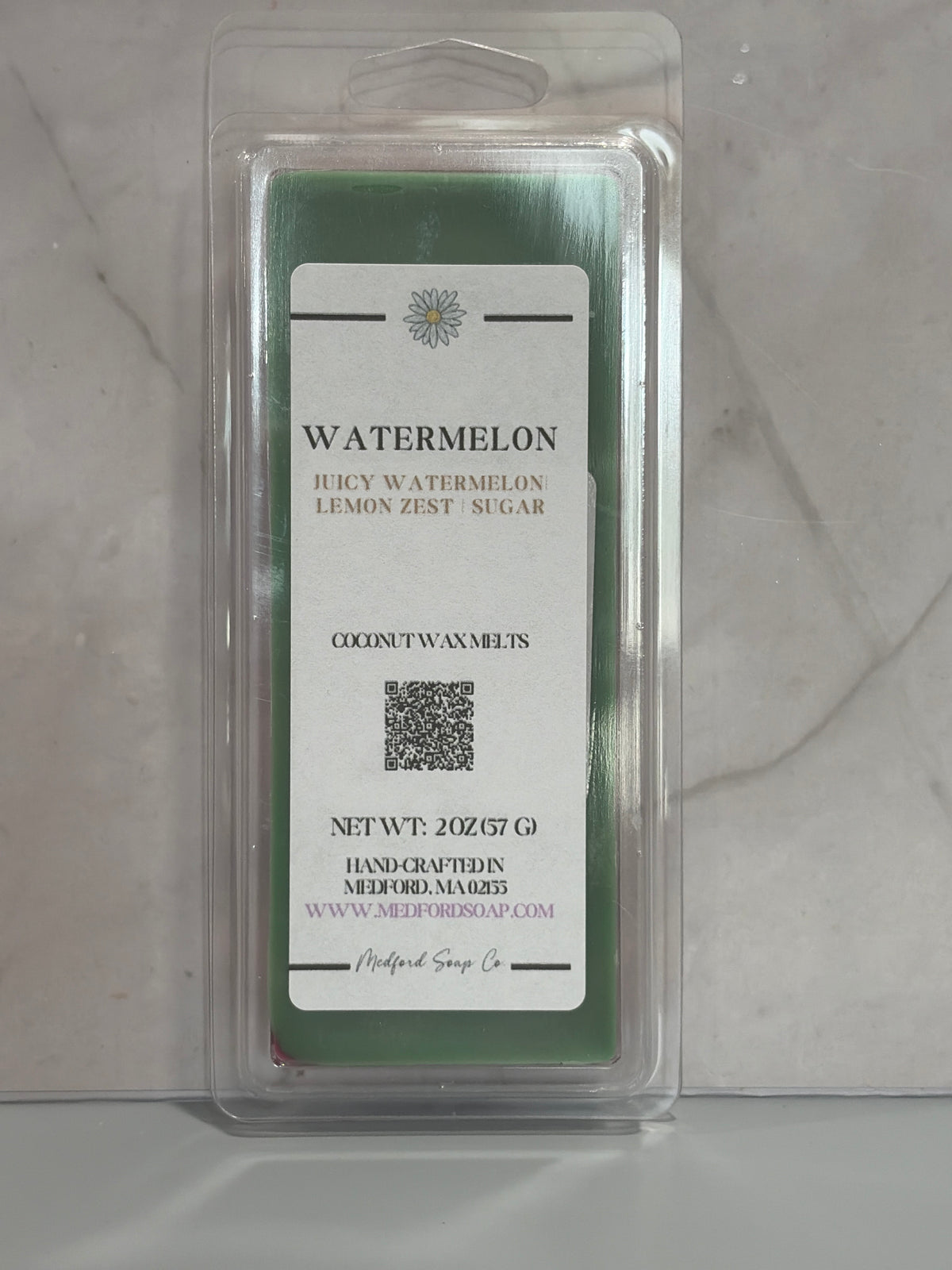 Watermelon scented wax melt package on a gray surface