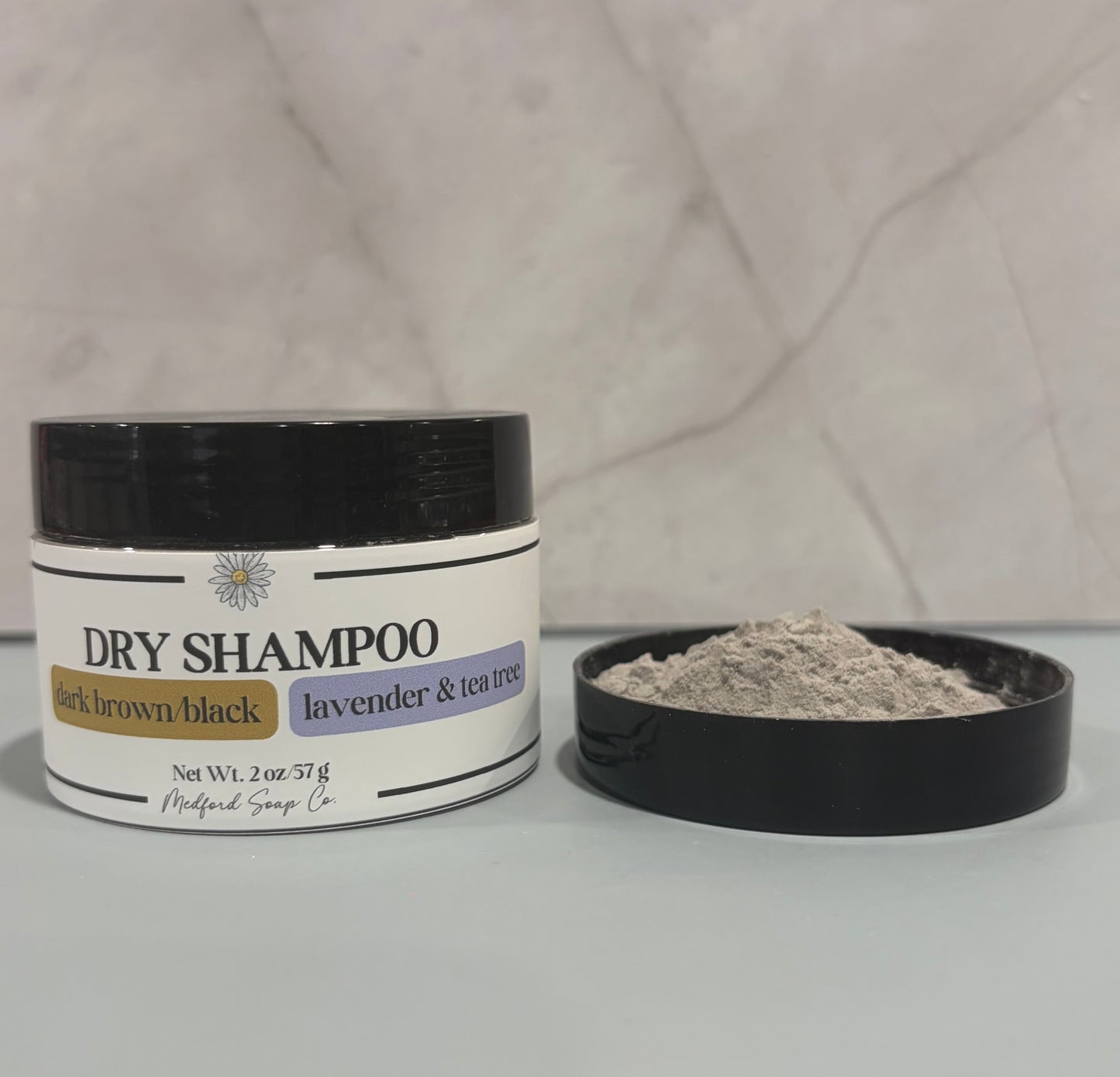 Dry shampoo jar with open lid on a gray background