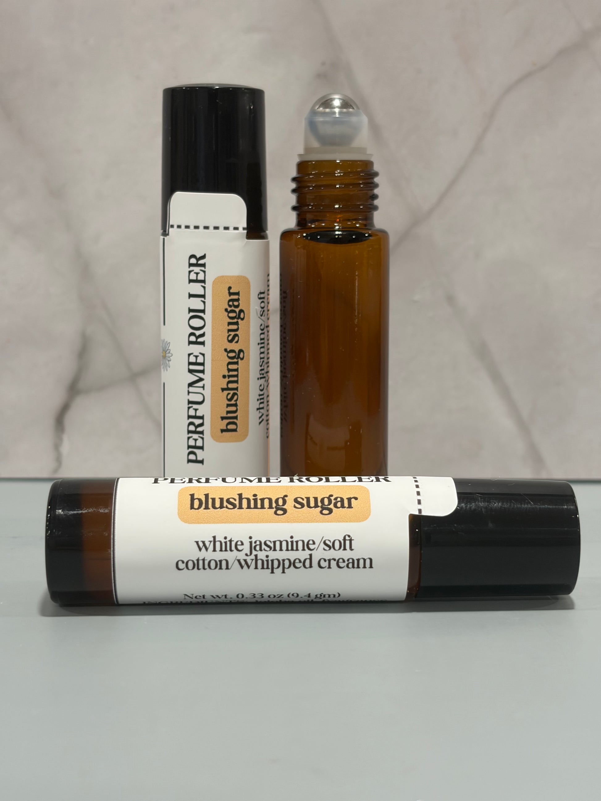 Three perfume rollers labeled 'blushing sugar' on a neutral background